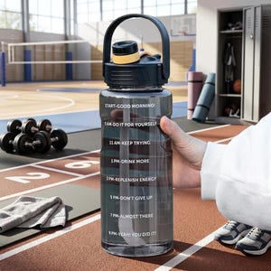 May include: A clear plastic water bottle with a black lid, a yellow accent, and a black carrying handle. The bottle features white text with a time-based hydration schedule: START-GOOD MORNING, 9 AM-DO IT FOR YOURSELF, 11 AM-KEEP TRYING, 1 PM-DRINK MORE, 3 PM-REPLENISH ENERGY, 5 PM-DON'T GIVE UP, 7 PM-ALMOST THERE, 9 PM-YEAH! YOU DID IT!