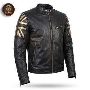 May include: A black leather jacket featuring a mandarin collar with two snap buttons, a central brass zipper, and gold-colored Union Jack flag accents on both shoulders. The jacket includes a zippered chest pocket and two lower zippered pockets.