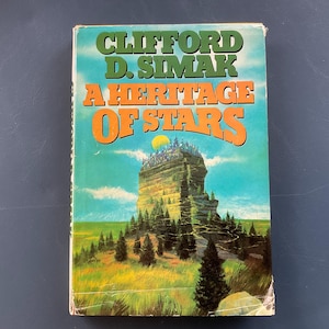 May include: A vintage paperback book titled "A Heritage of Stars" by Clifford D. Simak. The cover features a landscape with a large rock formation topped with a city, under a yellow sun. The title is in orange and the author's name is in green.