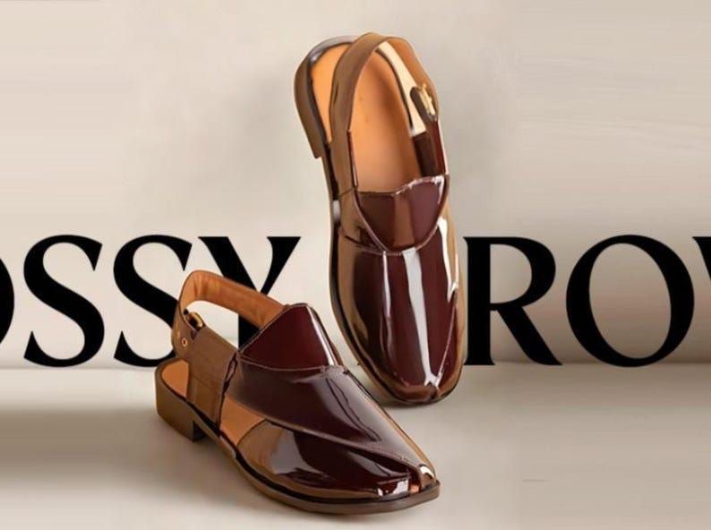 May include: Two pairs of glossy, dark brown leather sandals with a slingback design. The sandals have a polished finish and a contrasting light brown interior. The background features the word "RO" in black.
