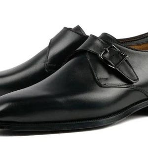 May include: A pair of black leather monk strap shoes. These shoes have a single buckle fastening and a polished finish. The design is classic, suitable for formal or business wear. The shoes are approximately 30 cm long.