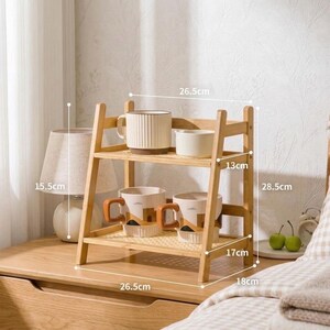 Puede incluir: Una estanter&iacute;a de bamb&uacute; de dos niveles, de 67,3 cm de ancho y 28,5 cm de alto, exhibe tazas. La balda superior contiene una taza acanalada y un cuenco blanco peque&ntilde;o. La balda inferior tiene tres tazas con asas marrones y un dise&ntilde;o geom&eacute;trico.