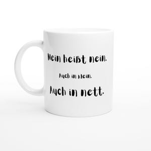 Könnte beinhalten: Eine weiße Keramiktasse mit einem Henkel auf der linken Seite. Die Tasse ist mit schwarzem Text bedruckt, der lautet: Nein heißt nein. Auch in klein. Auch in nett. Das Design ist mittig auf der Vorderseite der Tasse platziert und in einer schlichten Schriftart gehalten.