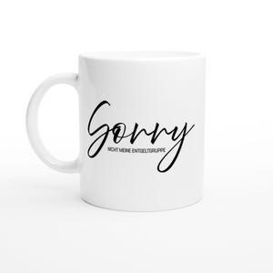 May include: White ceramic mug with black script text reading "Sorry" above "NICHT MEINE ENTGELTGRUPPE". The mug has a curved handle and is set against a white background.