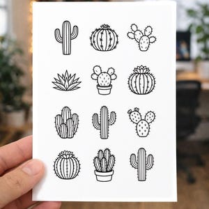 May include: A white card with black line drawings of cacti. The illustrations show different cactus varieties, some potted, arranged in a grid. The card is held by a hand, with the background out of focus.