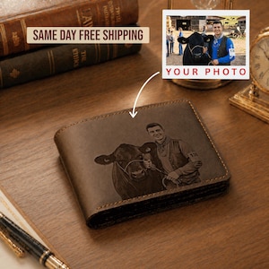 May include: A brown leather bi-fold wallet featuring a laser-engraved image of a person standing next to a cow. The engraving depicts the person wearing a vest and holding a lead rope attached to the cow, matching the provided reference photo.