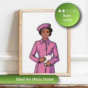 May include: A framed cross-stitch portrait of a woman in a pink coat and hat, holding a white object. The artwork is labeled "Basic Level" and is ideal for an 18x24 inch frame. The frame is made of light-colored wood.
