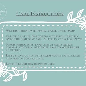 May include: A light blue rectangular sign with white floral borders and the text CARE INSTRUCTIONS. It provides steps for using a dish brush and soap bar, including wetting the brush, creating a lather, scrubbing dishes, rinsing, and drying the brush.