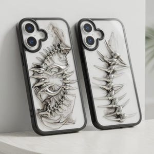 May include: Two phone cases with a black frame and a white background. Each case features a silver-colored, three-dimensional spine design. The cases have a glossy finish and are displayed against a neutral background.