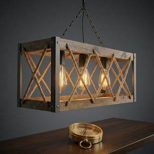 May include: A rectangular, rustic-style pendant light fixture with three Edison-style bulbs. The wooden frame is accented with metal and rope detailing. The light hangs from a chain. A brass compass sits on a dark wooden surface below.