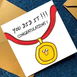 K&ouml;nnte beinhalten: Eine quadratische Gru&szlig;karte mit einer Cartoon-Illustration einer Goldmedaille an einem roten Band. Die Medaille hat ein l&auml;chelndes Gesicht mit err&ouml;teten Wangen. Der Text auf der Karte lautet: YOU DID IT !!! CONGRATULATIONS ! Wei&szlig;e Karte.