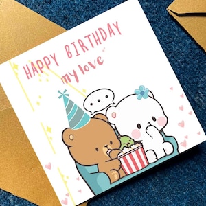 May include: A birthday greeting card with the text "HAPPY BIRTHDAY my love" in pink. The card features cartoon bears, one brown and one white, with a party hat and popcorn. The card is on a blue surface with a gold envelope.