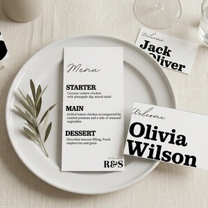 May include: A table setting with white place cards and a menu. The menu lists a starter, main course, and dessert. There are also name cards that say "Welcome" and the names "Jack Oliver" and "Olivia Wilson". A table number 6 is also present.