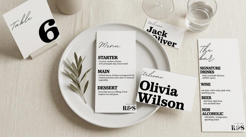 May include: A table setting with white place cards and a menu. The menu lists a starter, main course, and dessert. There are also name cards that say "Welcome" and the names "Jack Oliver" and "Olivia Wilson". A table number 6 is also present.