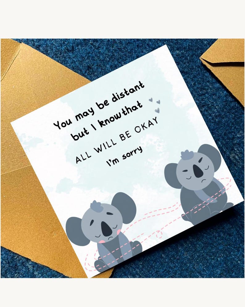 May include: A greeting card with a light blue background and the text "You may be distant but I know that ALL WILL BE OKAY I'm sorry". The card features two cartoon koalas and a gold envelope.