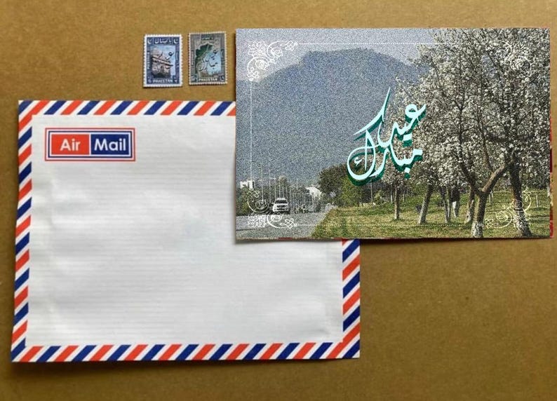 May include: An Air Mail envelope with red, white, and blue stripes and the words "Air Mail" in a red box. A postcard with a mountain scene and Arabic script is next to the envelope, along with two postage stamps.