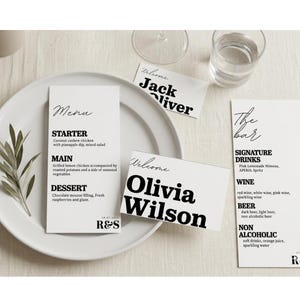 May include: A table setting with a white plate, menu, and name cards. The menu lists a starter, main course, and dessert. Name cards read "Jack Oliver" and "Olivia Wilson." A bar menu lists signature drinks, wine, beer, and non-alcoholic options.