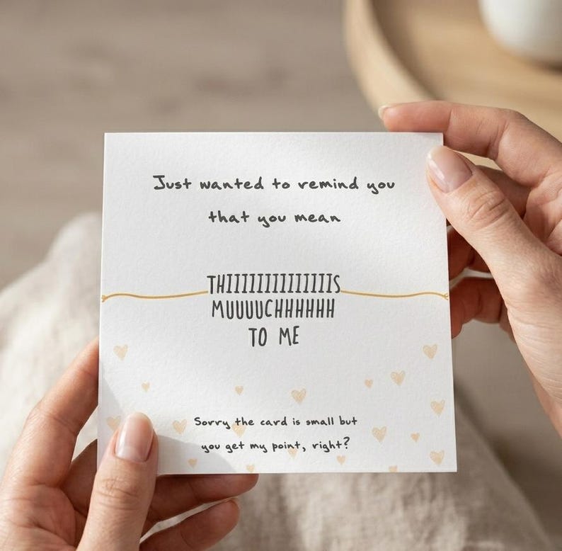 Puede incluir: Una tarjeta blanca con el texto "Just wanted to remind you that you mean THIIIIIIIIIIIIIIS MUUUUCHHHHHH TO ME." Peque&ntilde;as ilustraciones de corazones est&aacute;n dispersas por la tarjeta. Tambi&eacute;n se incluye el texto "Sorry the card is small but you get my point, right?"