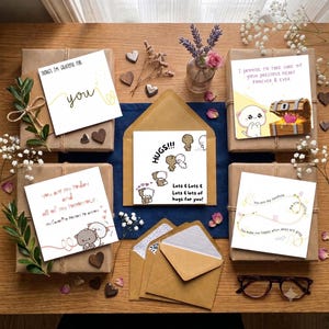 Puede incluir: Una colecci&oacute;n de cinco tarjetas de felicitaci&oacute;n cuadradas con personajes de dibujos animados y textos rom&aacute;nticos, incluyendo frases como 'Things I'm grateful for', 'Hugs', 'I promise to take care of your precious heart' y 'You are my sunshine', dispuestas sobre una superficie de madera.