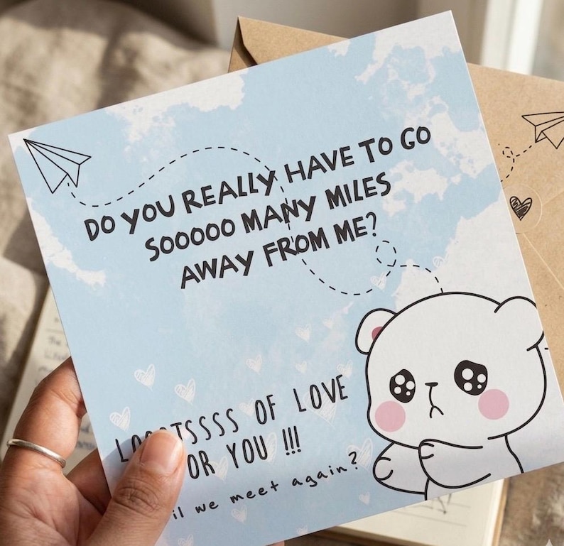 May include: A light blue greeting card with a sad bear illustration and the text "Do you really have to go so many miles away from me? Lots of love for you!!! Will we meet again?" A paper airplane is drawn on the card.