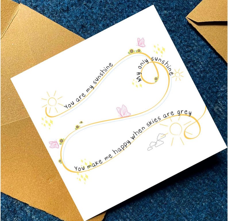 Puede incluir: Una tarjeta de felicitaci&oacute;n cuadrada con fondo blanco y una l&iacute;nea amarilla en forma de infinito. El texto dice: You are my sunshine, My only sunshine, You make me happy when skies are grey. Decorada con peque&ntilde;os girasoles, mariposas rosas y soles.