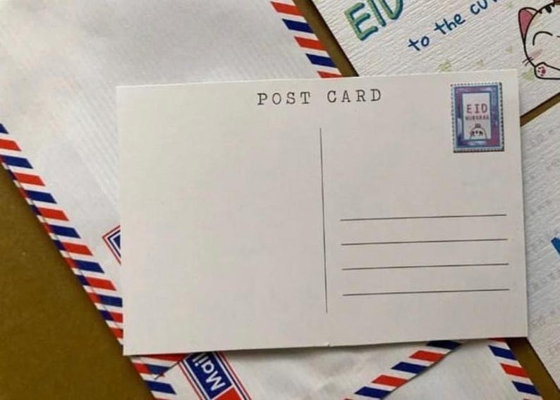 May include: A white postcard with the words "POST CARD" printed at the top. The postcard has lines for writing and a stamp with the word "EID" on it. The postcard is on top of an envelope with red, white, and blue stripes.