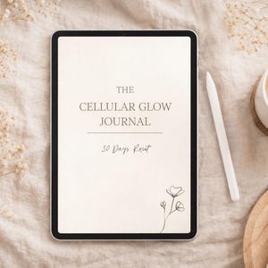 Könnte beinhalten: Ein digitales Tablet mit der Aufschrift "THE CELLULAR GLOW JOURNAL" und dem Text "30 Days Reset". Ein weißer Stift, eine Tasse Kaffee und ein Untersetzer und Teller aus Holz befinden sich neben dem Tablet. Der Hintergrund ist ein beiger Stoff mit getrockneten Blumen.