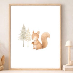 Könnte beinhalten: Gerahmter Aquarelldruck eines Eichhörnchens, das eine Eichel hält, vor stilisierten Bäumen. Das Kunstwerk ist in einem hellen Holzrahmen präsentiert. Die Farbpalette ist sanft, mit Beige-, Braun- und Weißtönen, was eine ruhige und natürliche Ästhetik erzeugt.