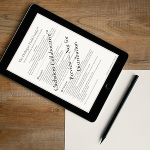 May include: A black tablet displaying text from "The Dialogue Field Guide" and "Chehalem Collaborative" on a wooden surface. A blank white paper and a black pencil are also on the table. The text includes "Preview Not for Distribution".