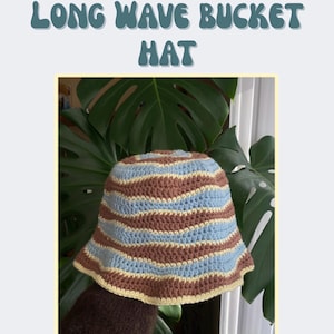 May include: A crochet bucket hat featuring horizontal wavy stripes in light blue, brown, and pale yellow. The text "LONG WAVE BUCKET HAT" appears at the top, along with the logo and contact information for Under the Yew, and a footer note.