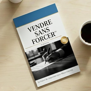 May include: A book titled "VENDRE SANS FORCER" with a blue and white cover, featuring a person writing on paper. The book is by decisiona and has a gold seal that says "SYSTÈME PROUVÉ". A small succulent plant in a white pot and a cup of coffee are also visible.