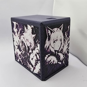 May include: A dark purple, rectangular box featuring raised, white-and-purple anime-style character reliefs on two visible sides. The character has pointed ears, short hair, and is surrounded by dynamic, jagged energy patterns in a high-contrast design.