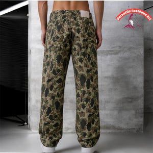 May include: Camouflage-patterned pants in shades of green, brown, and black. The pants have a relaxed fit and a light-colored patch on the back. The image shows the back of the pants.