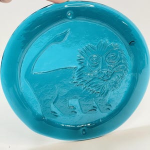 May include: A white ceramic mug with a black handle and the text "But First, Coffee" in a black, handwritten-style font. The mug is on a white surface.