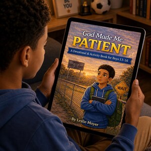 May include: A person holding a tablet displaying the cover of "God Made Me Patient," a devotional book for boys aged 13-16. The cover art features a young boy in a blue hoodie and backpack, standing near a fence. The book's title is in large, bold letters.