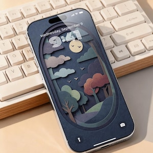 Puede incluir: Un smartphone con una pantalla azul oscuro que muestra un paisaje de papel recortado con árboles, nubes y un sol. La pantalla muestra la fecha, miércoles 9 de septiembre, y la hora, 9:41. El teléfono está junto a un teclado blanco.