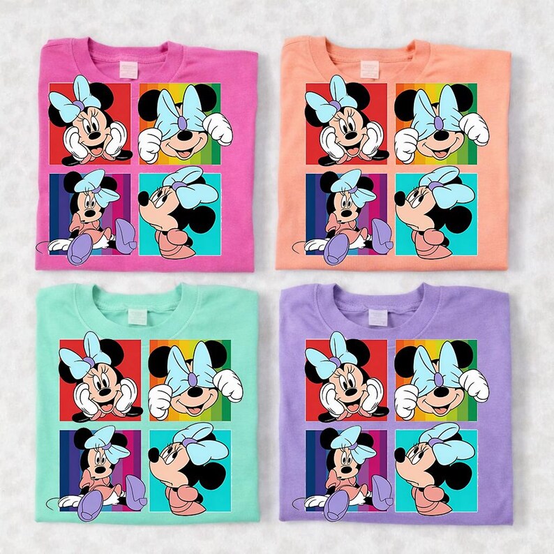 May include: Four colorful t-shirts featuring a Minnie Mouse graphic. Each shirt has a different background color: pink, peach, mint green, and lavender. The graphic is a grid of four images of Minnie Mouse with a blue bow.