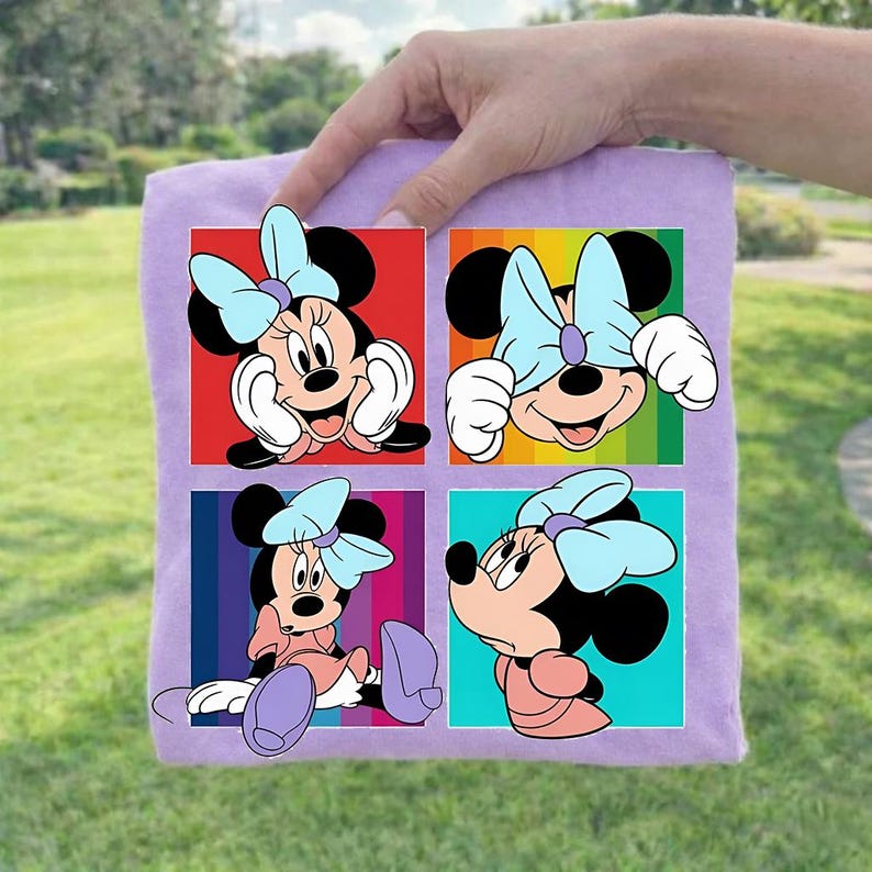 May include: A lavender square fabric featuring four colorful squares with Minnie Mouse illustrations. Each square showcases a different pose of Minnie Mouse, with her signature bow and outfit. The background colors include red, rainbow, blue, and turquoise.