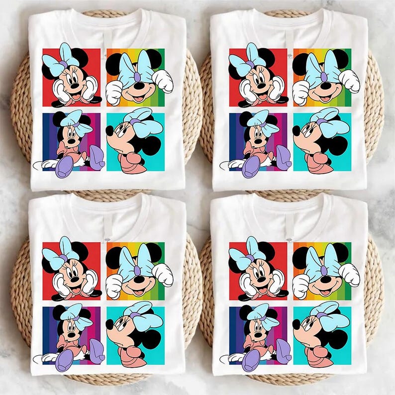 May include: Four white t-shirts with a colorful graphic of Minnie Mouse. Each shirt features a grid of four images of Minnie Mouse with a light blue bow. The background colors are red, yellow, green, and blue.