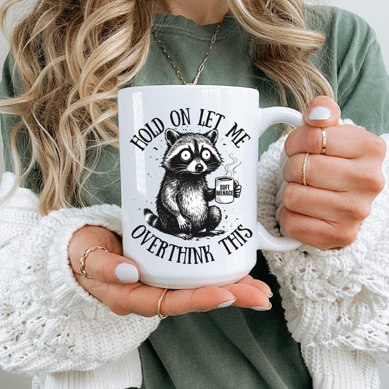 Hold On Let Me Overthink This ceramic mug — Soft Menace raccoon design — funny coffee mug — overthinking gift — raccoon meme mug — pairs with the raccoon graphic tee — Soft Menace Co