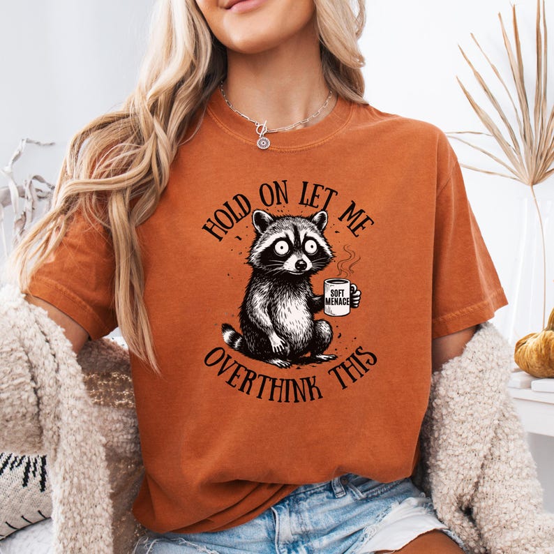 Raccoon shirt in Terracotta — Hold On Let Me Overthink This graphic tee on model — Comfort Colors 1717 warm rust colorway — funny oversized women’s shirt — raccoon meme tee — soft garment dyed