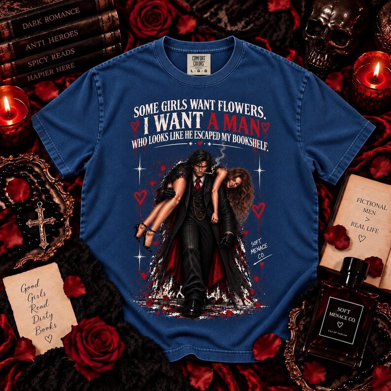 Blue Jean Comfort Colors 1717 dark romance reader shirt featuring distressed cream and blood red gothic artwork of a brooding fictional man carrying a woman with “Some Girls Want Flowers, I Want a Man Who Looks Like He Escaped My Bookshelf.” Spicy reader graphic tee for BookTok fans, book boyfriend lovers, morally gray men readers, fictional boyfriend enthusiasts, romance novel lovers, gothic book lovers, and dark romance readers by Soft Menace Co.