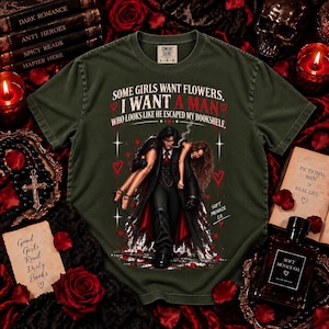 Moss green Comfort Colors 1717 dark romance shirt featuring distressed cream, black, and deep red artwork with a dark-haired fictional book boyfriend carrying a woman and “Some Girls Want Flowers, I Want a Man Who Looks Like He Escaped My Bookshelf.” Bookish graphic tee for dark romance readers, spicy book lovers, BookTok fans, fictional men enthusiasts, morally gray romance lovers, gothic readers, and women who love romance novel inspired clothing.