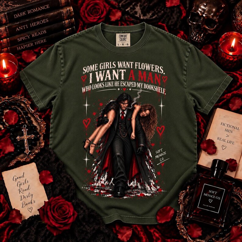 Moss green Comfort Colors 1717 dark romance shirt featuring distressed cream, black, and deep red artwork with a dark-haired fictional book boyfriend carrying a woman and “Some Girls Want Flowers, I Want a Man Who Looks Like He Escaped My Bookshelf.” Bookish graphic tee for dark romance readers, spicy book lovers, BookTok fans, fictional men enthusiasts, morally gray romance lovers, gothic readers, and women who love romance novel inspired clothing.