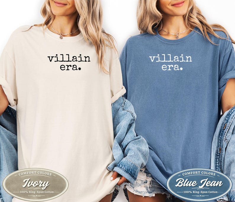 May include: Two t-shirts, one ivory and one blue jean, each with the text "villain era." printed in black and white. The ivory shirt has a Comfort Colors label that says "Ivory" and "100% Ring-Span Cotton." The blue jean shirt has a Comfort Colors label that says "Blue Jean" and "100% Ring-Spun Cotton."