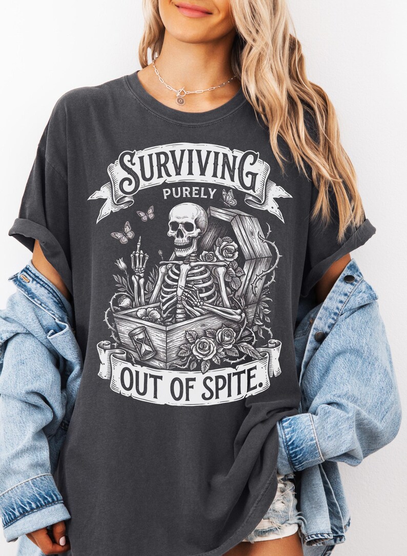 Pepper skeleton shirt worn with denim jacket. Gothic coffin and roses graphic tee on Comfort Colors 1717. Dark humor dark academia shirt — Surviving Purely Out Of Spite. Soft garment-dyed blank.​​​​​​​​​​​​​​​​