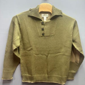 May include: Olive green sweater with a ribbed collar and three brown buttons. The sweater has elbow patches and the brand name "ORVIS" is visible on the label. The sweater is hanging on a wooden hanger.