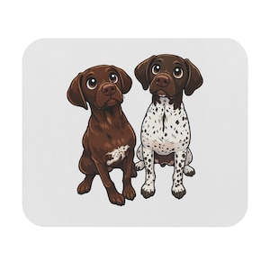 May include: A white mouse mat with a cartoon illustration of two German Shorthaired Pointers. One is solid brown, the other is white with brown spots. Both dogs have brown eyes and are sitting, looking upwards.
