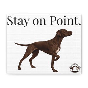 May include: Canvas print featuring a brown dog in a pointing stance, with the text "Stay on Point." The dog has a white patch on its chest. The Brothers Braque logo is in the lower right corner.