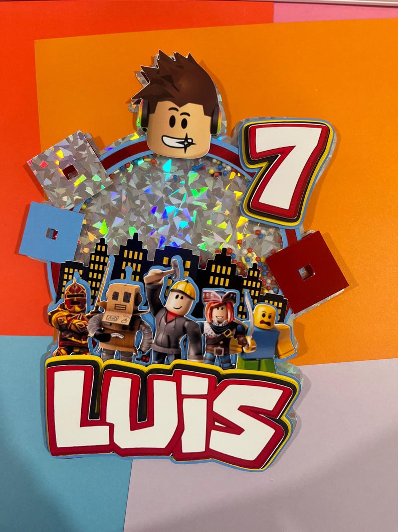 May include: A colorful birthday cake topper featuring a Roblox character head, the number 7, and the name "LUIS". The design includes various Roblox avatars and city skyline silhouettes, with a background of sparkling confetti.
